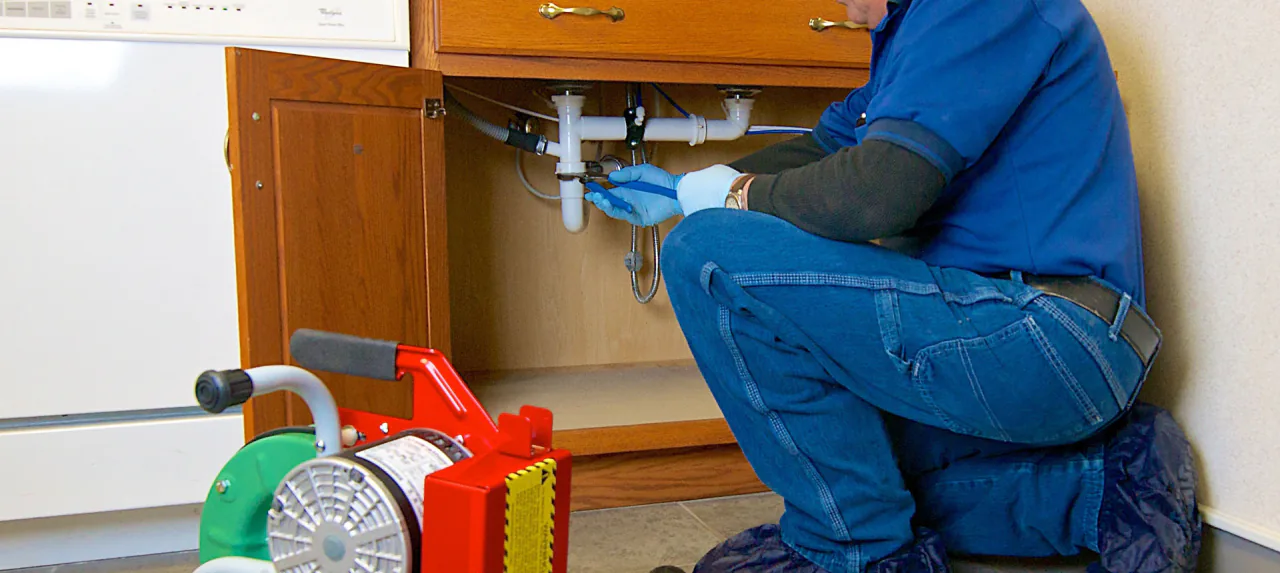 A Bob Frame Plumbing technician clearing a kitchen drain